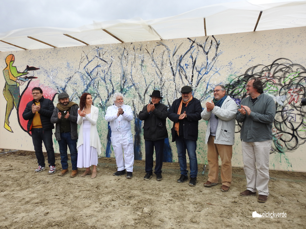 Cristóbal Gabarrón, de blanco, posa junto a parte de los artistas participantes y el comisario de la cita ante el mural 'Flores contra bombas'